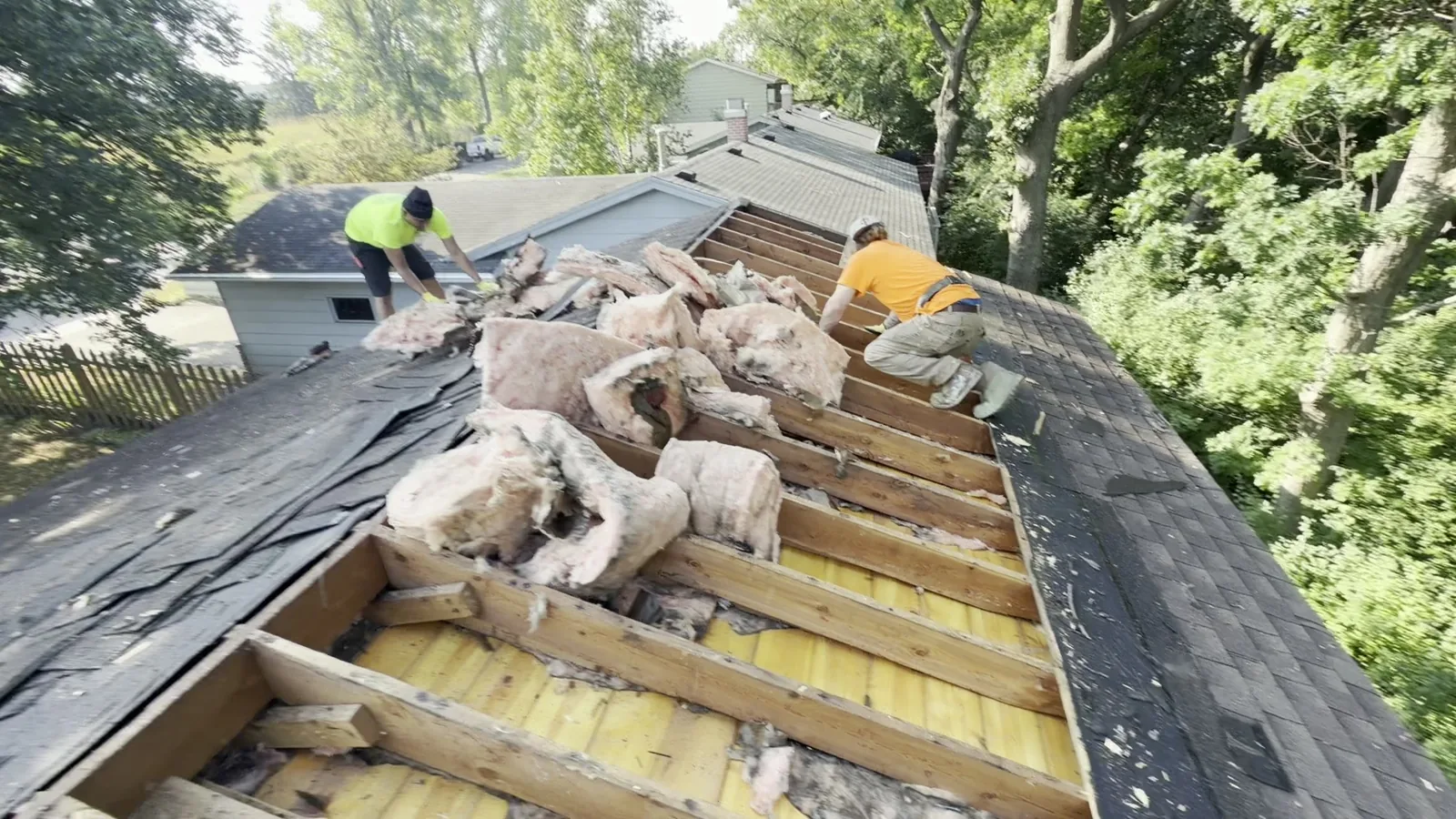 Installers on roof removing old insulation